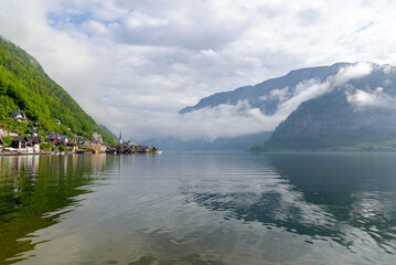 Obraz premium spring landscape of austrian mountain village Hallstatt and Hallstatter lake, low clouds over the mountains