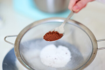  spoon of cocoa added to flour, healthy home baking concept