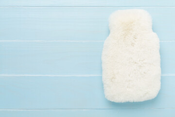 Fluffy water warmer bag on wooden background, top view