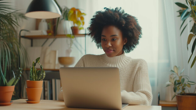 An African-American female student studies a virtual course, takes a web-based distance learning course, looks at a laptop computer 