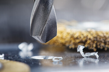 metal drill bit make holes in steel billet on industrial drilling machine
