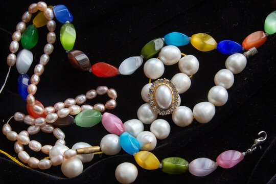 Chains of colors stones and pearls on blavk background