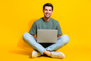 Full length photo of funny good mood guy wear khaki t-shirt chatting apple samsung isolated yellow color background