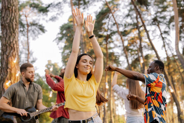 Multiracial group of people, beautiful hipster woman dancing on the background of friends having fun