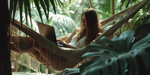 Woman Laying in hammock and using laptop computer. Happy worker remote or virtual, working on vacation - weekend overtime business and technology concept - obrazy, fototapety, plakaty