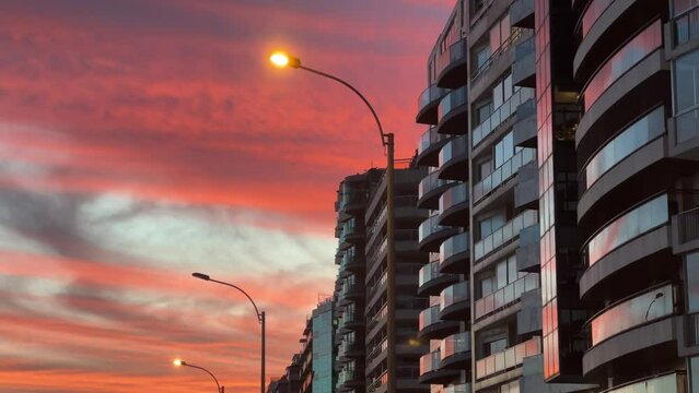 A beautiful view of the buildings along the Rambla in Montevideo, Uruguay, with a stunning sunset in the background.