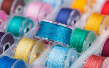 Plastic bobbins for a sewing machine with multi-colored threads.
