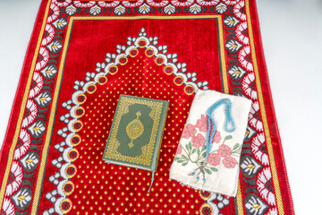 Rahle with Quran and Rosary on Muslim prayer rug.Ramadan Concept