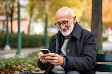 An elderly gentleman in casual attire, with a joyful smile, sits on a park bench, engrossed in his smartphone, surrounded by nature and urban elements