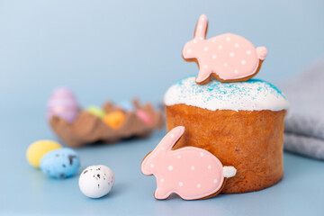 Pink gingerbread in the form of a rabbit on an Easter cake on blue background