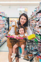Asian mother and her daughter buying food at huge supermarket ,Hand holding a product box mockup...