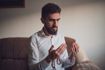 Religious young arab muslim man, holding palms face up, whispering pray. Religion, islam, believing...