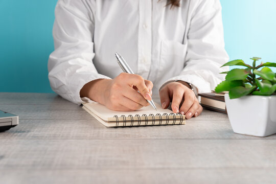 Woman making notes in notepad, business concept