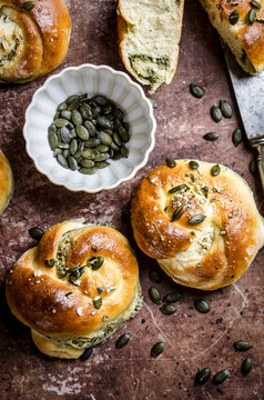 Buns with pumpkin seed cream sprinkled with pumpkin seeds on stressed baking sheet