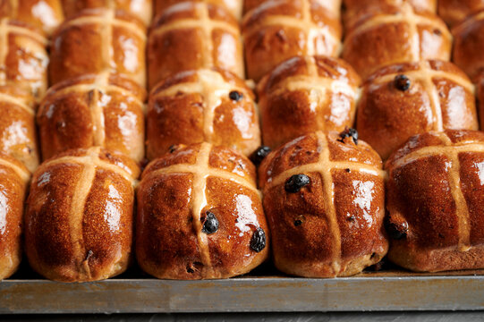 Tray of glazed fruit hot cross buns made with yeast and sourdough
