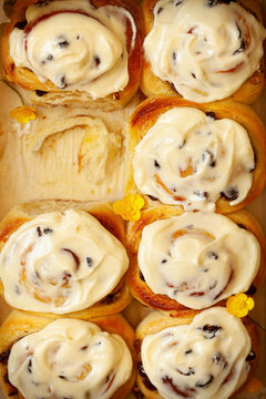 Lemon rolls freshly baked and topped with cream cheese frosting.  They are ready to pull apartand one has been taken already.