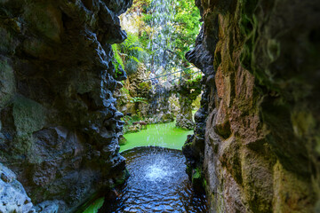 View from behind a small waterfall at the base of the ceremonial Initiation Well and spiral...