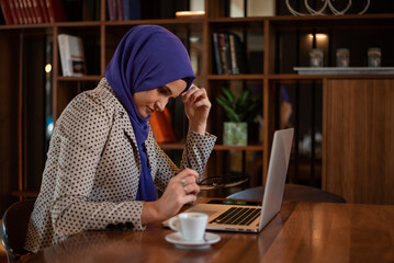 Muslim Business woman or female student with hijab under stress from too much work in the office