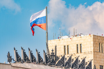 Waving national flag of russian federation on top of government stalin era empire building in...