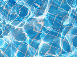 Detalle de la supreficie de agua en una piscina iluminada por el sol 