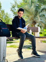 Young teenager reading a book in a park Kuwait City