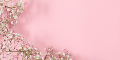 Small white gypsophila flowers on pastel pink background. Happy Women's Day, Wedding, Mother's Day,...