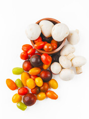 Colorful tomatoes and mushrooms isolated on white background. Top view.