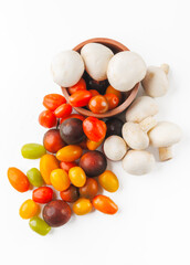 Colorful tomatoes and mushrooms isolated on white background. Top view.