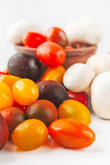 Colorful tomatoes and mushrooms isolated on white background. Top view.
