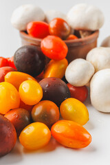 Colorful tomatoes and mushrooms isolated on white background. Top view.