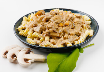 pasta with meat and mushroom sauce on a plate on a white background
