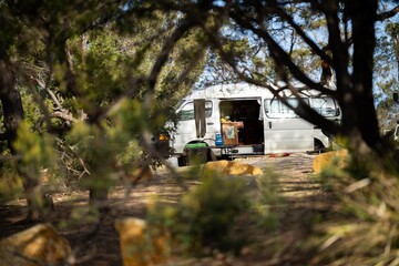 camping in a tent and van in the australian bush. Caravan camping at a camp ground off grid on a holiday in spring. - obrazy, fototapety, plakaty