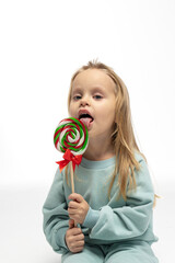 Portrait of funny little blonde girl with sweets lollipop in her hand. High quality photo