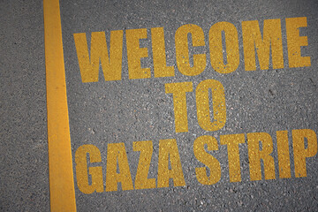 asphalt road with text welcome to Gaza Strip near yellow line.