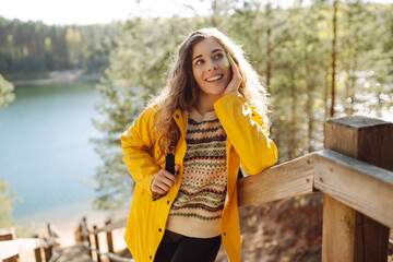 Woman traveler on a wooden ladder. Young woman enjoying nature on a sunny day. Active lifestyle. Travel concept.