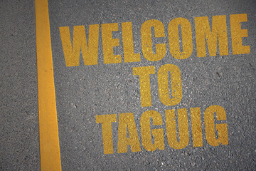 asphalt road with text welcome to Taguig near yellow line.