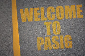 asphalt road with text welcome to Pasig near yellow line.