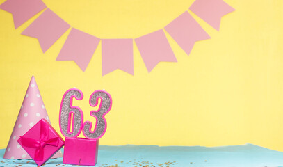 Date of birth for a girl  63. Copy space. Birthday in pink shades with a yellow background....