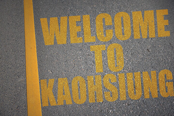 asphalt road with text welcome to Kaohsiung near yellow line.