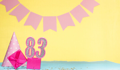 Date of birth for a girl  83. Copy space. Birthday in pink shades with a yellow background....