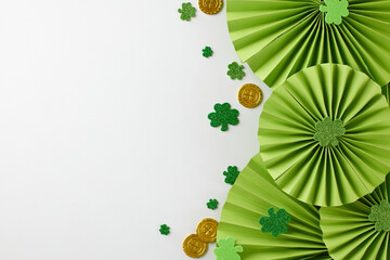 Cheerful сeltic сarnival: joyful St. Patrick's Day festivities. Top view photo of folding fans, trefoils, coins, beads on white background with space for greeting text