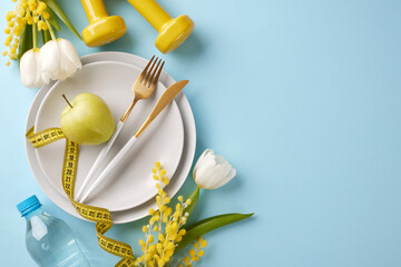 Slimming into spring: revitalize your body and mind. Top view shot of plates, cutlery, apple,...