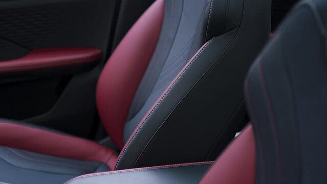 Witness the captivating beauty of a close-up shot featuring the intricate design and luxurious upholstery of the red and black car seat in modern car SUV.