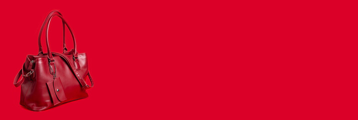 Red women's leather bag on a red background. Banner