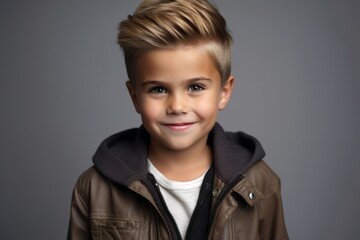 Portrait of a cute little boy in a brown leather jacket.