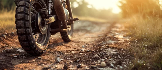 Fotobehang A rugged motorcycle kicks up a cloud of dust as it tears through the grassy field, its tire treads gripping the soil with determination on the rough dirt road © Radomir Jovanovic