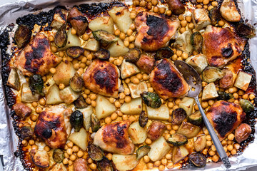 Roasted chicken with vegetables on a sheet pan hot out of the oven.