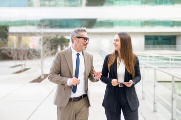 In this candid shot, the businessman with salt-and-pepper hair shares a laugh with a younger...