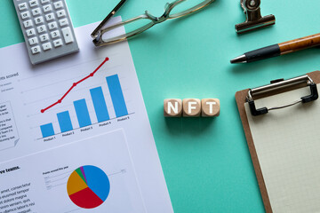 There is wood cube with the word NFT. It is an abbreviation for Non-Fungible Token as eye-catching...