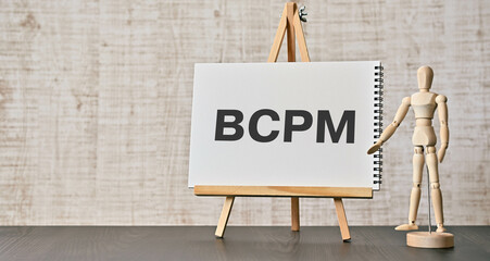 There is notebook with the word BCPM. It is an abbreviation for Business Continuity Plan Management as eye-catching image. - obrazy, fototapety, plakaty